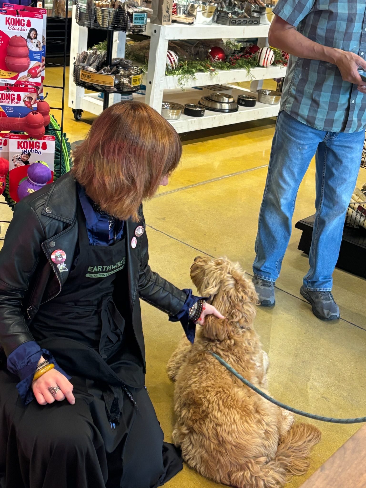 Staff with a golden doodle puppy inside Earthwise Pet South Lamar
